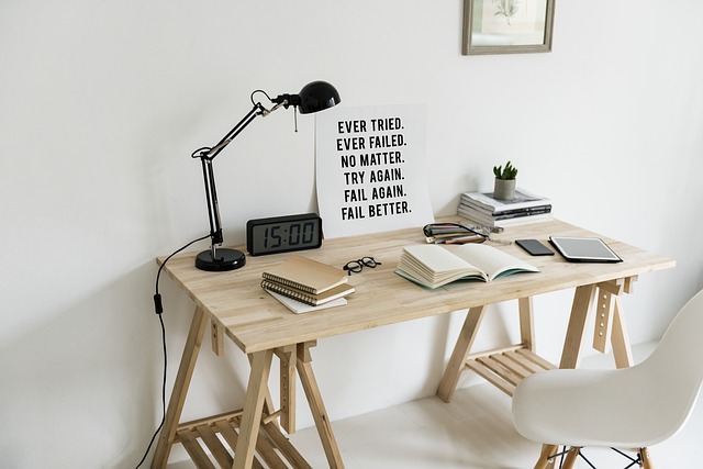 Světlý psací stůl s učebnicemi, k němu je přistavená židle